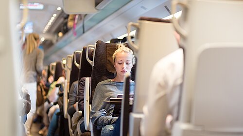 Lady sitting on a train.